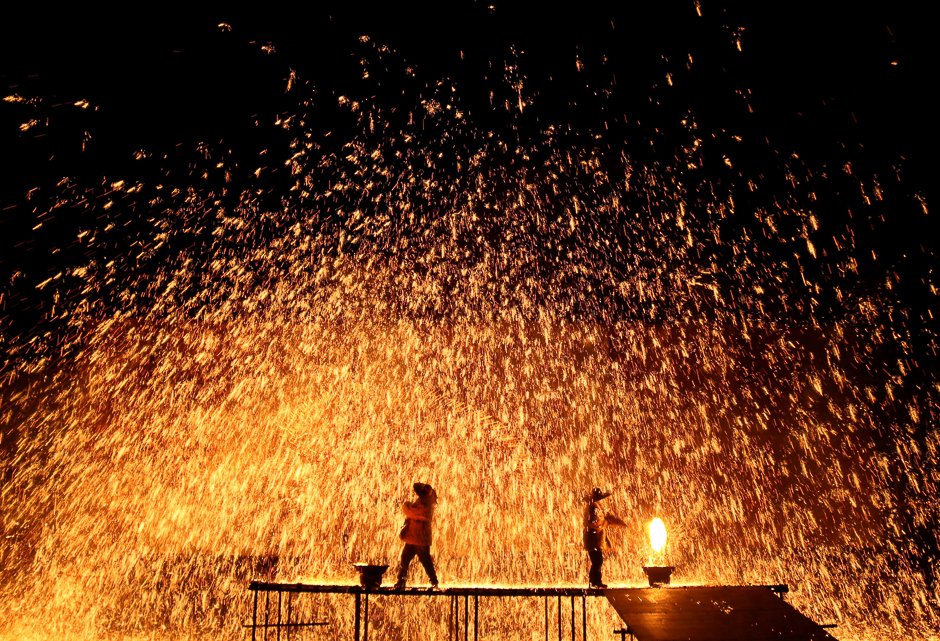 performers throw molten iron against a wall to create sparks during a traditional performance ahead of the dragon boat festival in zhangjiakou hebei province china photo reuters