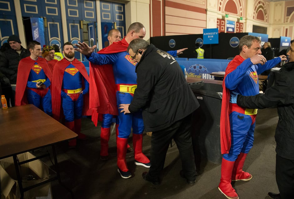 Fans wearing fancy dress are searched as they arrive ahead of the PDC World Championship darts final between Netherlands' Michael van Gerwen and Scotland's Gary Anderson at Alexandra Palace in north London. PHOTO: AFP