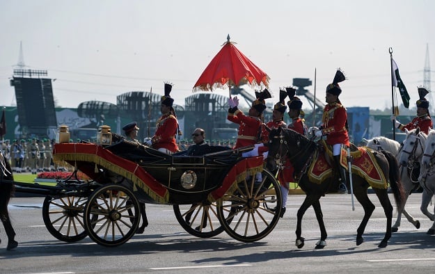 Pakistan's President Mamnoon Hussain (C) rides a horse-drawn carriage escorted by presidential guards as he arrives at the venue for the Pakistan Day military parade in islamabad on March 23, 2018. PHOTO: AFP