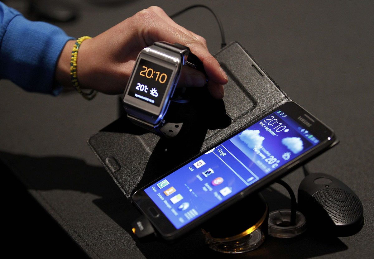 a journalist looks at a samsung galaxy gear smartwatch l and galaxy note 3 r after their launch photo reuters