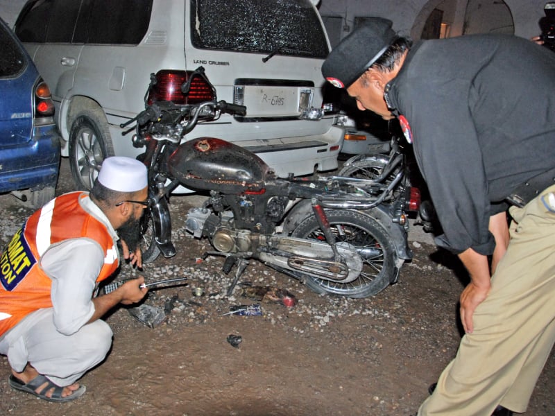 a policeman inspects the motorcycle used in the blast photo sameer raziq express