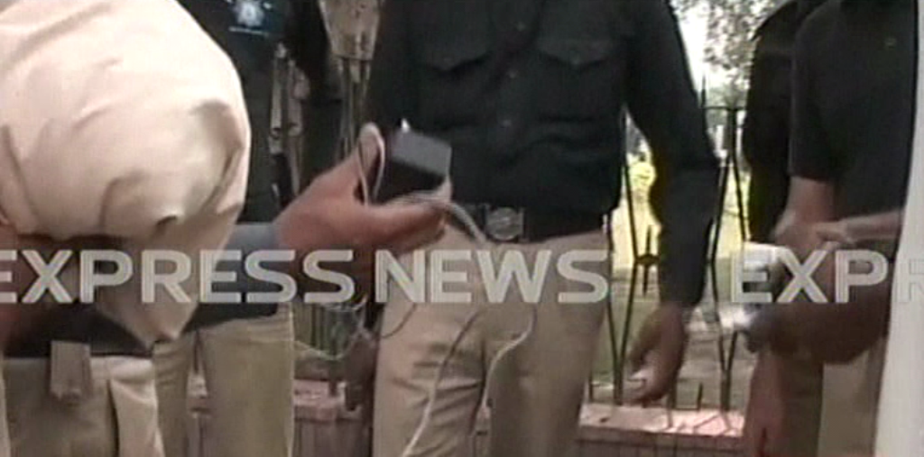 a screengrab of policemen holding the remote and wires found with the bomb photo express