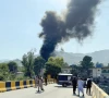 people and police gather near the crash site of a pakistan army aviation mi 17 helicopter near muzaffarabad as smoke billows from the wreckage photo reuters