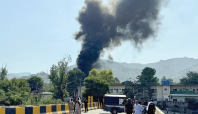 people and police gather near the crash site of a pakistan army aviation mi 17 helicopter near muzaffarabad as smoke billows from the wreckage photo reuters
