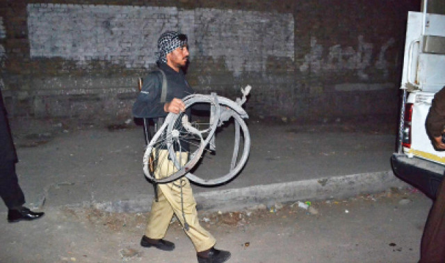 a policeman carries the cycle used in the blast photo online a policeman carries the cycle used in the blast photo online