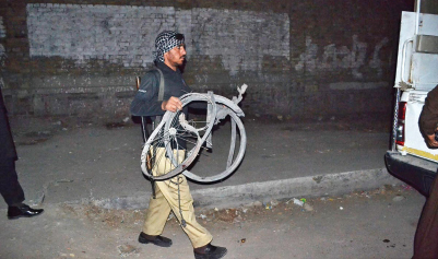 a policeman carries the cycle used in the blast photo online