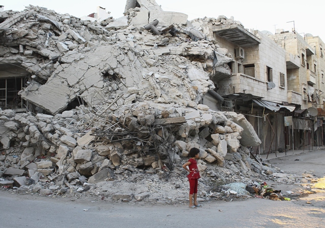 a girl stands in front of a building damaged by what activists said was shelling by forces loyal to syria 039 s president bashar al assad photo reuters