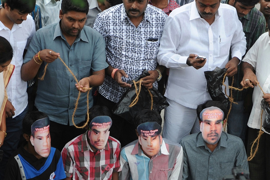 in this photograph taken on september 13 2013 members of the karnataka state youth congress some of them wearing masks of the four convicted rapists enact a mock execution in bangalore following the sentencing in new delhi of four men convicted of rape and murder photo afp