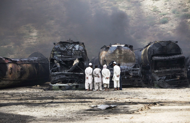men stand near damaged tankers of a nato supply convoy after an attack a day earlier in hub about 25 km from karachi september 16 2013 photo reuters men stand near damaged tankers of a nato supply convoy after an attack a day earlier in hub about 25 km from karachi september 16 2013 photo reuters