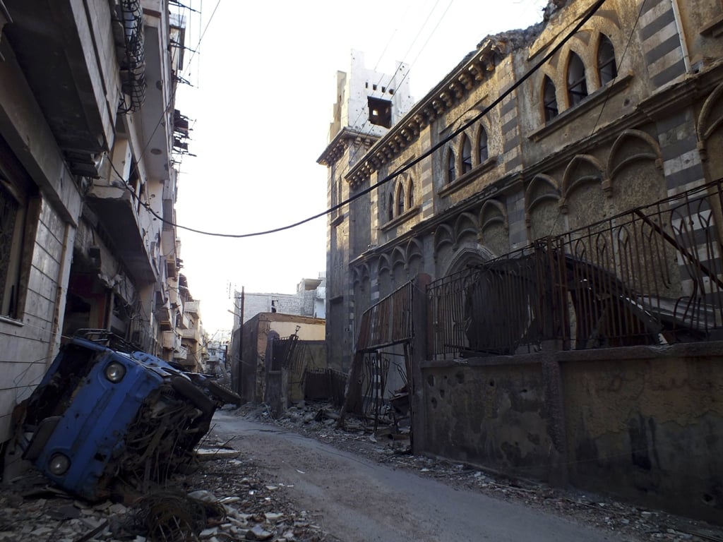 a damaged van is seen in front of an old damaged syriac catholic church in homs september 15 2013 photo reuters