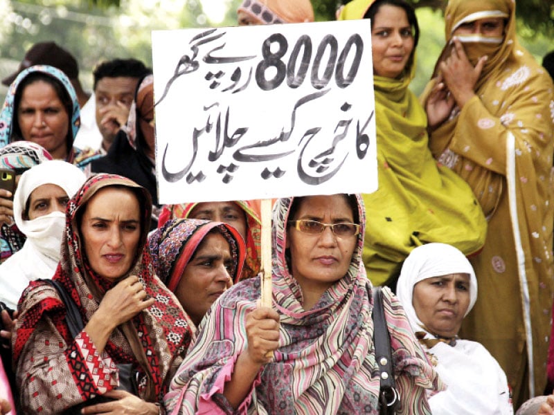 a worker holding up a placard asking how can we make ends meet with rs8 000 photo abid nawaz express