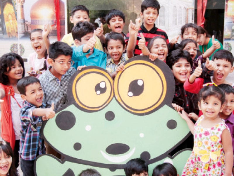 children attending the festival pose for a photograph with a cut out of a frog photo shafiq malik express