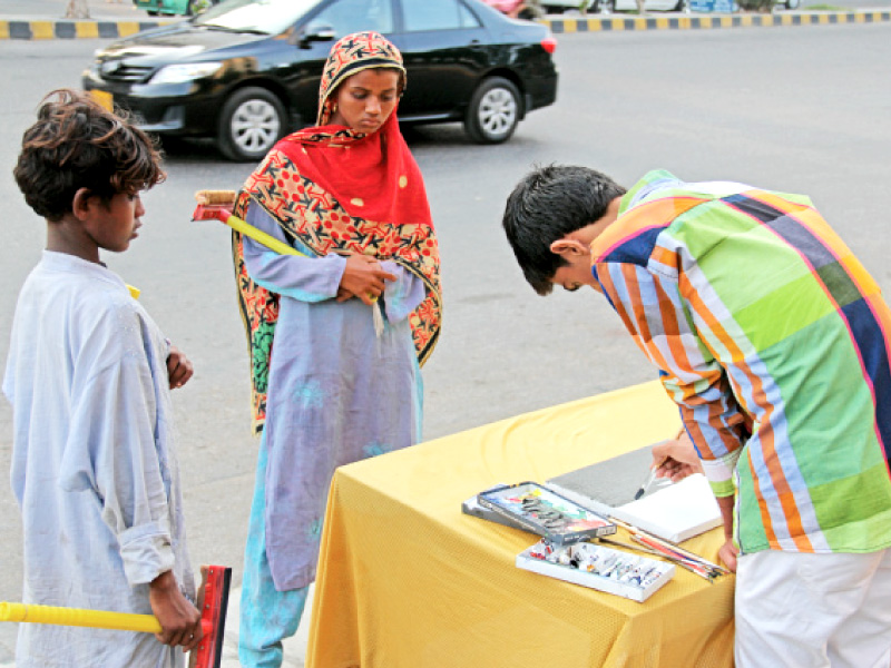 when ayub khan a class 10 student of lyari started painting by the roadside at teen talwar several beggars and car wipers gathered to watch him photo ayesha mir express