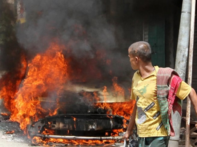 file photo of bangladeshi pedestrian walking past a burning vehicle after protests on september 17 photo afp file photo of bangladeshi pedestrian walking past a burning vehicle after protests on september 17 photo afp