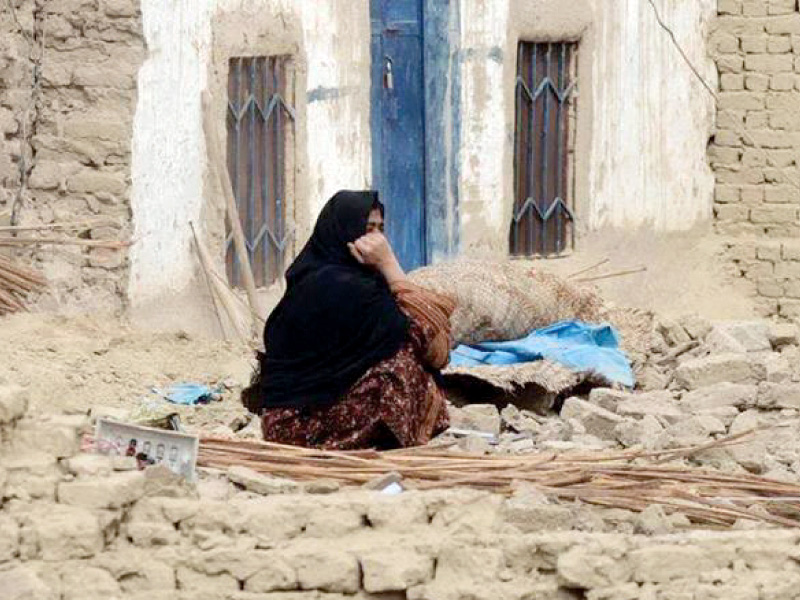 a distraught woman sits among the ruins of her collapsed house a typical scene of a building structure reduced to rubble an injured woman receiving medical attention photo agencies