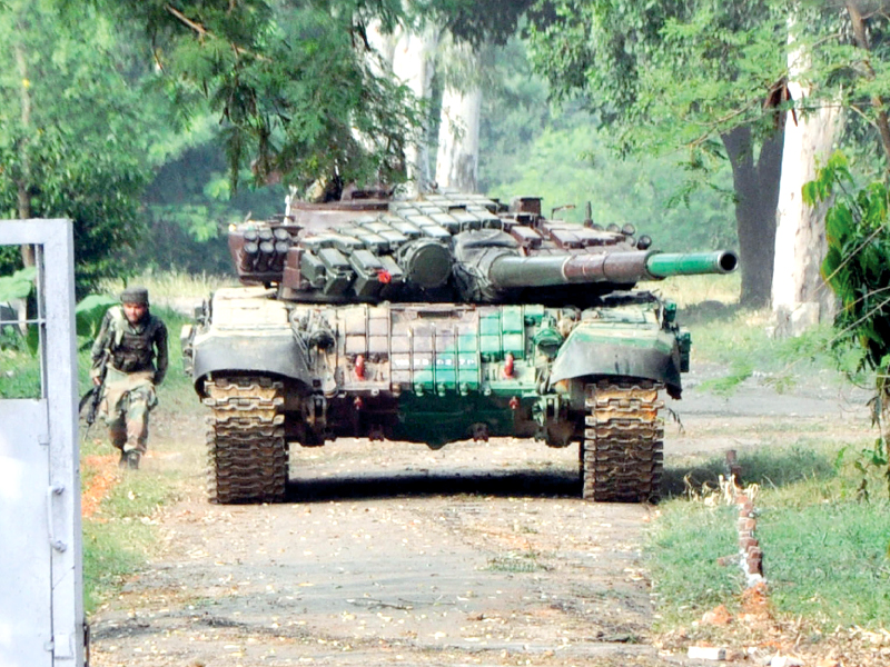 an indian soldier takes cover behind a tank used to force entry inside the officers mess of the army camp in samba during an attack by militants photo afp