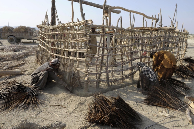 pakistani earthquake survivors prepare temporary huts for their family near their collapsed mud houses in the dhall bedi peerander area photo afp