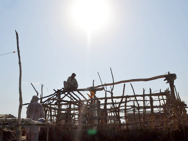 calamity hit people build homes from sticks and rags to save themselves from the scorching sun photo online