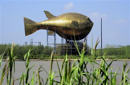 a viewing tower in the shape of a giant copper puffer fish is seen under construction on the banks of a river in yangzhong county jiangsu province photo reuter
