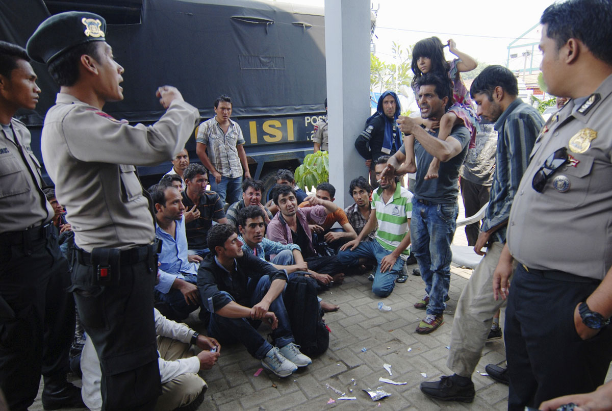 asylum seekers from afghanistan and pakistan argue with indonesian policemen at a temporary shelter in merak indonesia 039 s banten province september 27 2013 photo reuters