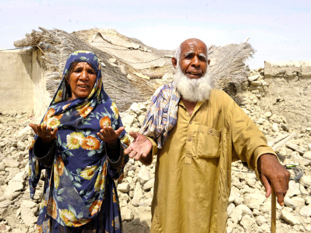 survivors plead for help in front of their destroyed house in awaran photo afp survivors plead for help in front of their destroyed house in awaran photo afp