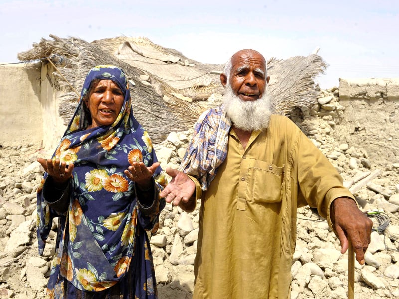 survivors plead for help in front of their destroyed house in awaran photo afp