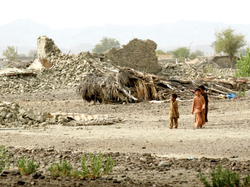 children walk near a destroyed building in the earthquake affected malaar area with no signs of aid or relief operations in sight photo athar khan express