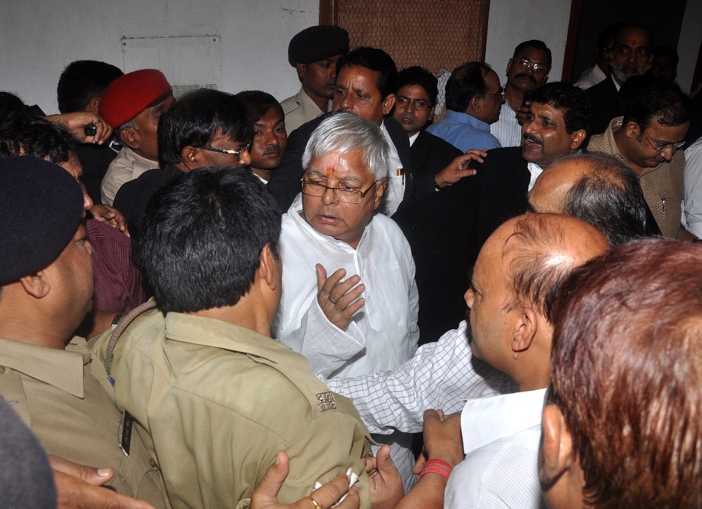 lalu prasad yadav c a former indian federal minister whose rashtriya janata dal party supports the ruling coalition is escorted out of court after a hearing in ranchi jharkhand on september 30 2013 photo afp