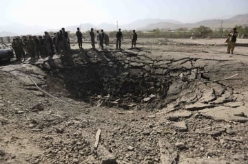 afghan policemen look on a crater at the scene of suicide attack in maidan shar the capital of wardak province photo reuters