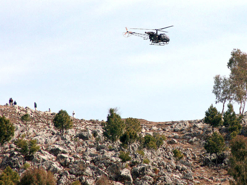 file photo of security officials and an army helicopter combing a hilly area following rocket attacks in abbottabad photo afp