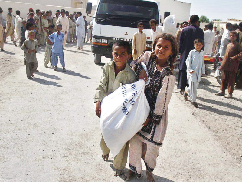 children carry relief items after collecting their shares from a camp set up in awaran district photo online