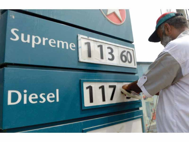 a worker changes the price figures at a filling station in karachi photo afp a worker changes the price figures at a filling station in karachi photo afp