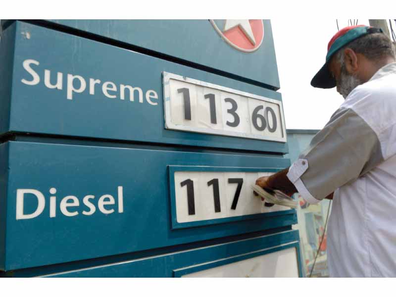 a worker changes the price figures at a filling station in karachi photo afp