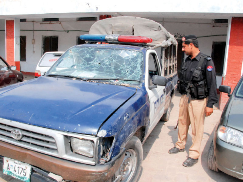 a policeman examines the battered vehicle after a roadside bomb blast in pishtakhara photo express