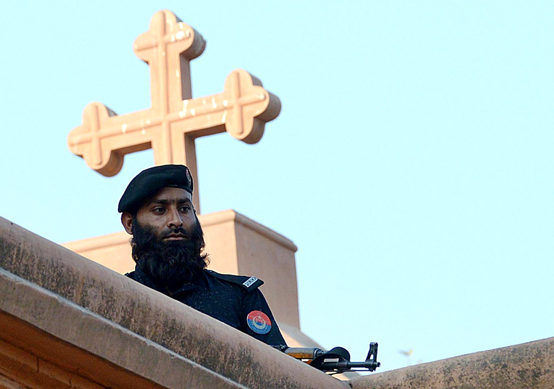 a policeman stands guard on the roof of a church during a special service for suicide bombing victims at a church in peshawar photo afp