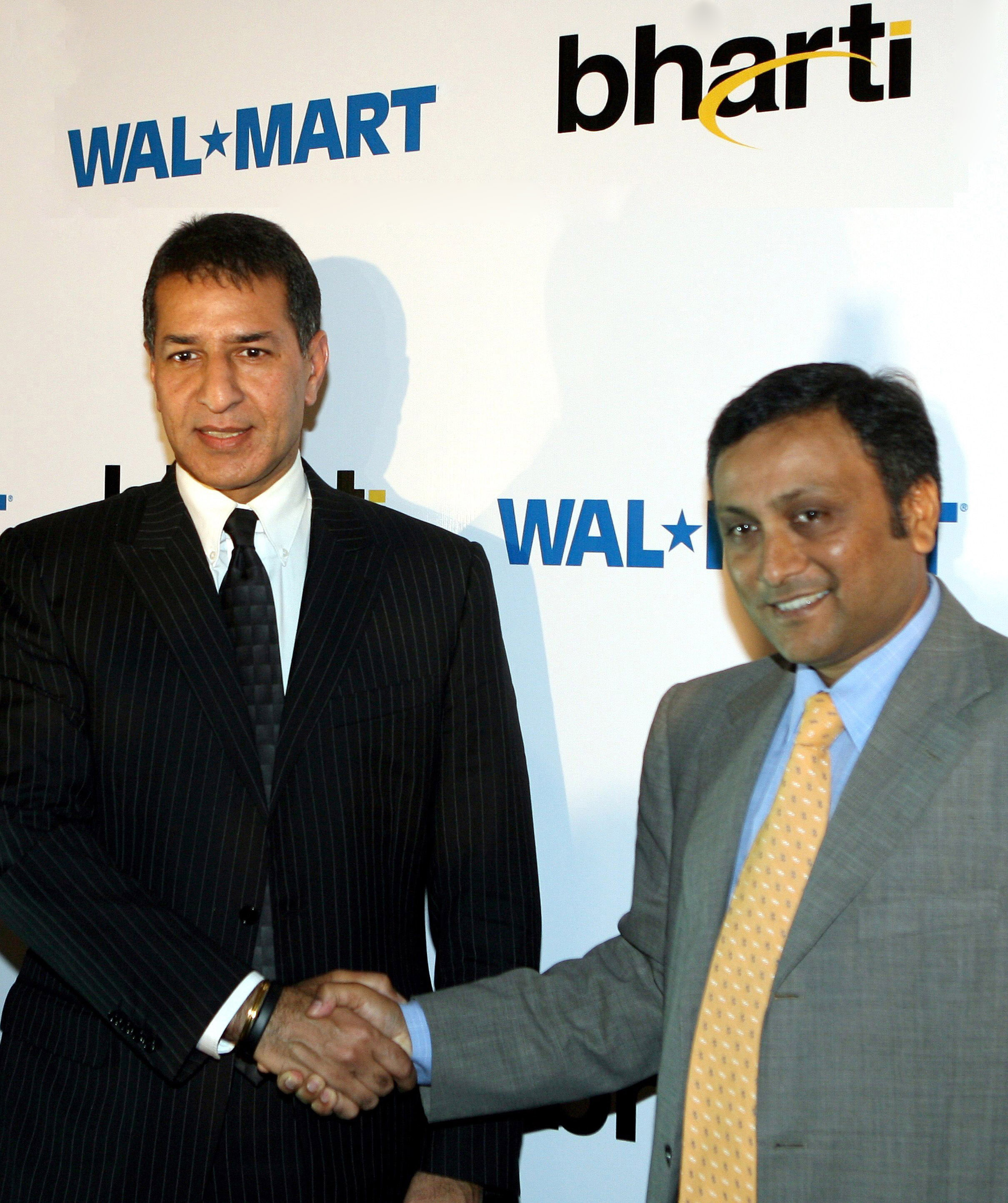 this photograph taken on august 6 2007 shows india 039 s bharti enterprises managing director rajan bharti mittal l shaking hands with raj jain president of us company wal mart 039 s operations in india during a press conference in new delhi photo afp