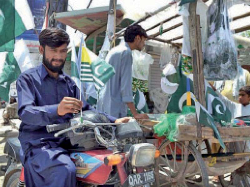 a man puts up a kashmiri flag on his motorcycle in quetta ahead of youm e istehsal which is being observed today wednes day to denounce the illegal occupation of kashmir by india photo app