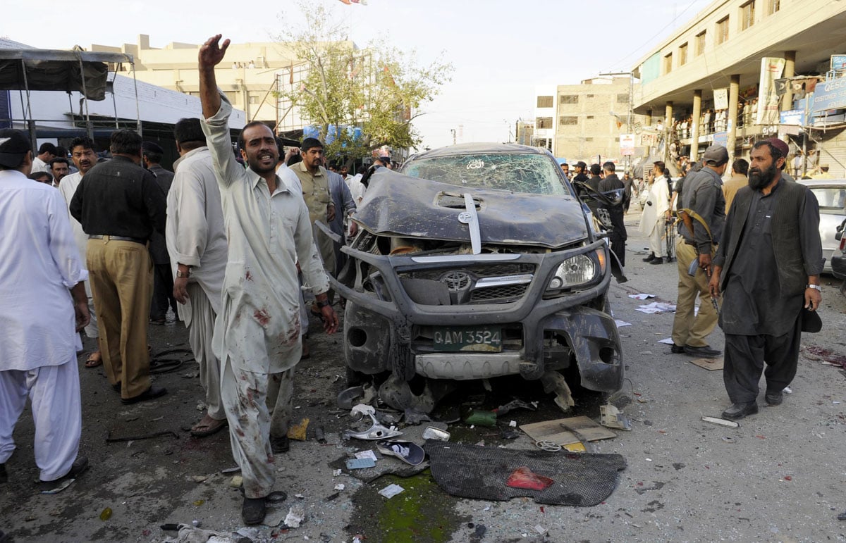 people gather at the site of a bomb blast where a bicycle bomb tore through a crowded market area near a police station in quetta on october 10 2013 photo afp