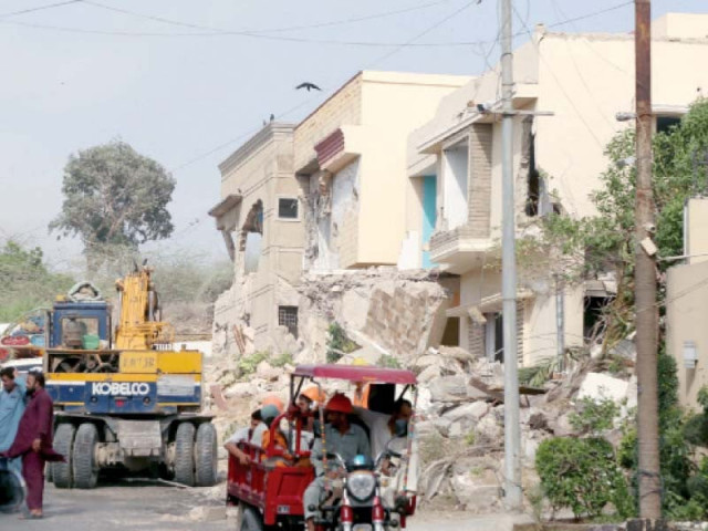 karachi metropolitan corporation s anti encroachment cell staff use heavy machinery to demolish four houses constructed on the land of hill park photo ppi karachi metropolitan corporation s anti encroachment cell staff use heavy machinery to demolish four houses constructed on the land of hill park photo ppi