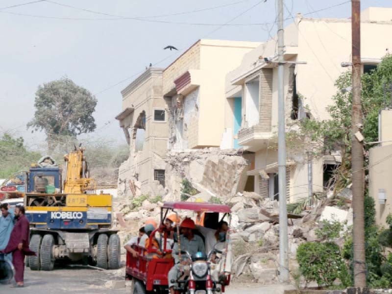 karachi metropolitan corporation s anti encroachment cell staff use heavy machinery to demolish four houses constructed on the land of hill park photo ppi