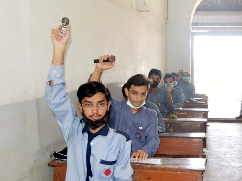 students show time on their wrist watches at ymca school examination centre where question paper had not arrived even after 10am although exam was to start at 9am photo jalal qureshi express file