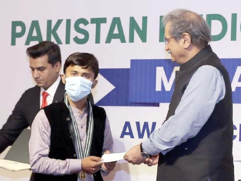 parkash kumar son of a poor mason belonging to minority community receives prize and a gold medal from the minister for federal education shafqat mahmood for securing top position in mdcat in sindh photo express