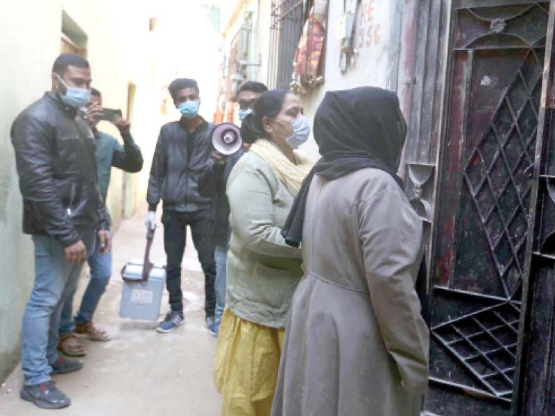 health workers visit a house in the gulberg area of karachi on tuesday as part of their efforts to vaccinate people at their homes against covid 19 photo ppi