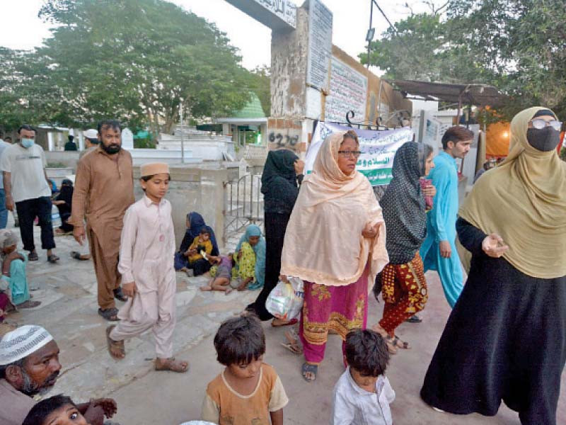 women enter the gate of dha phase i graveyard in karachi to visit the graves of their dearly departed ones photo express