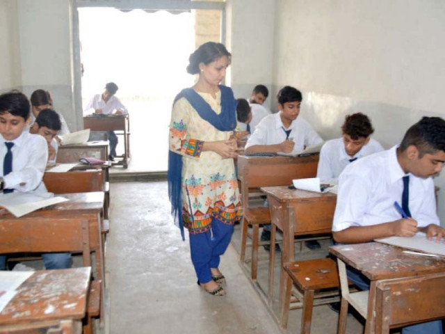 an invigilator keeps watch as students of grade ix solve paper on tuesday photo jalal qureshi express an invigilator keeps watch as students of grade ix solve paper on tuesday photo jalal qureshi express