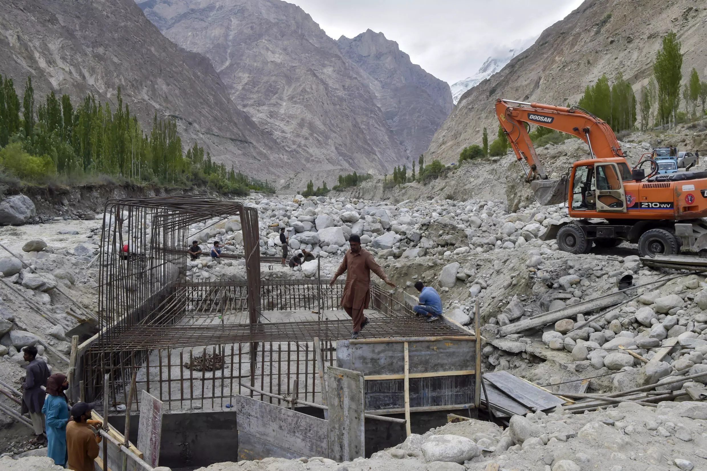 Workers constructing a temporary bridge in Hasanabad after the main bridge of the village was destroyed in floods.  AFP