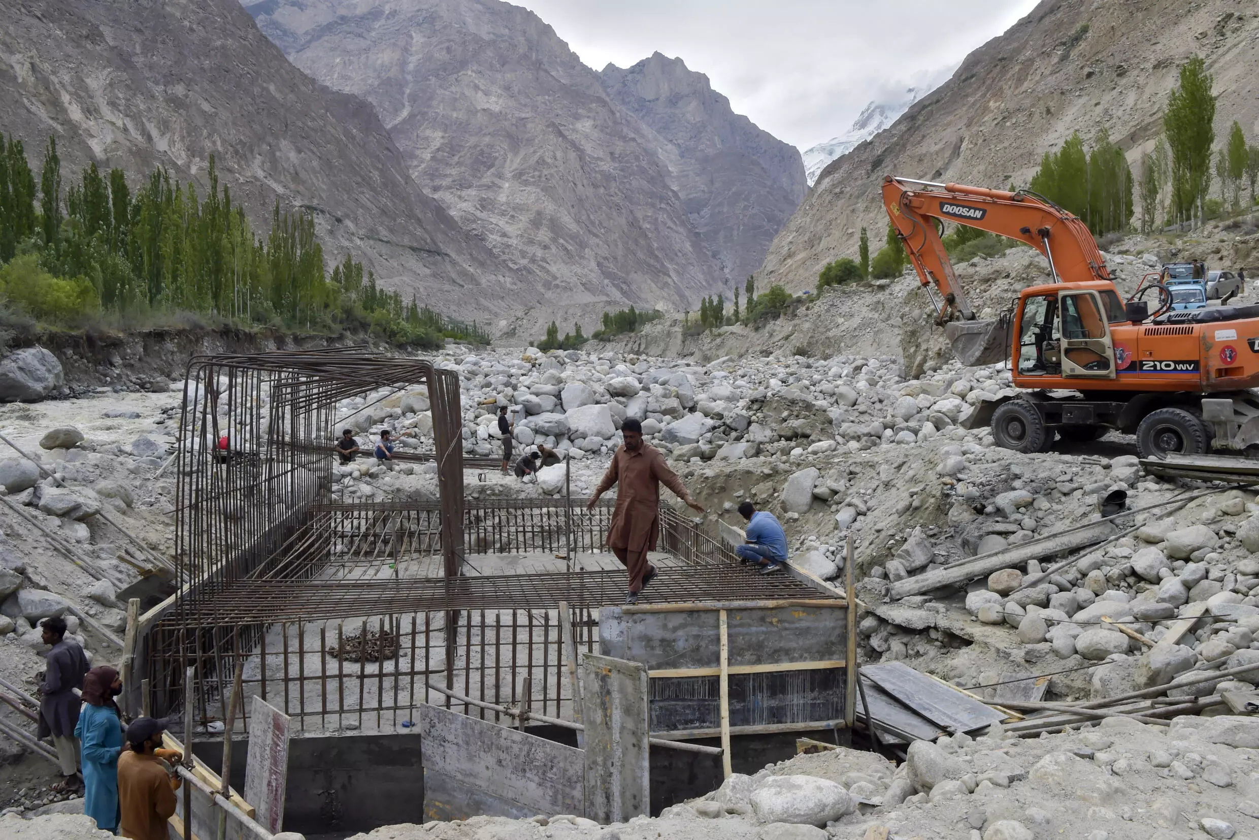 Construction workers build a temporary bridge in Hassanabad after the village's main bridge was destroyed in the flood. AFP