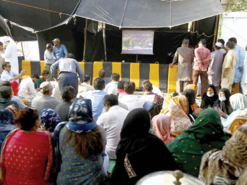 protesting doctors and paramedics watch t20 world cup match between pakistan and new zealand at their protest camp outside the sindh secretariat photo ppi