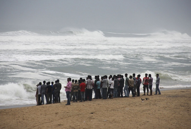 people watch as waves from the bay of bengal approach the shore at podampata village in ganjam district in the eastern indian state of odisha october 11 2013 photo reuters