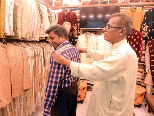 a tailor takes measurements of a client at his shop in saddar karachi photo jalal qureshi express a tailor takes measurements of a client at his shop in saddar karachi photo jalal qureshi express